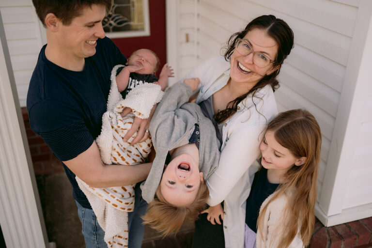 Family plays and laughs with each other during a newborn home session.