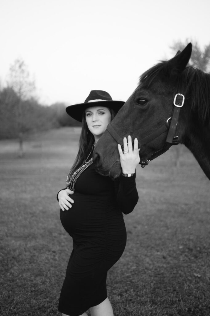 mom to be poses for her portrait with a horse in Arkansas