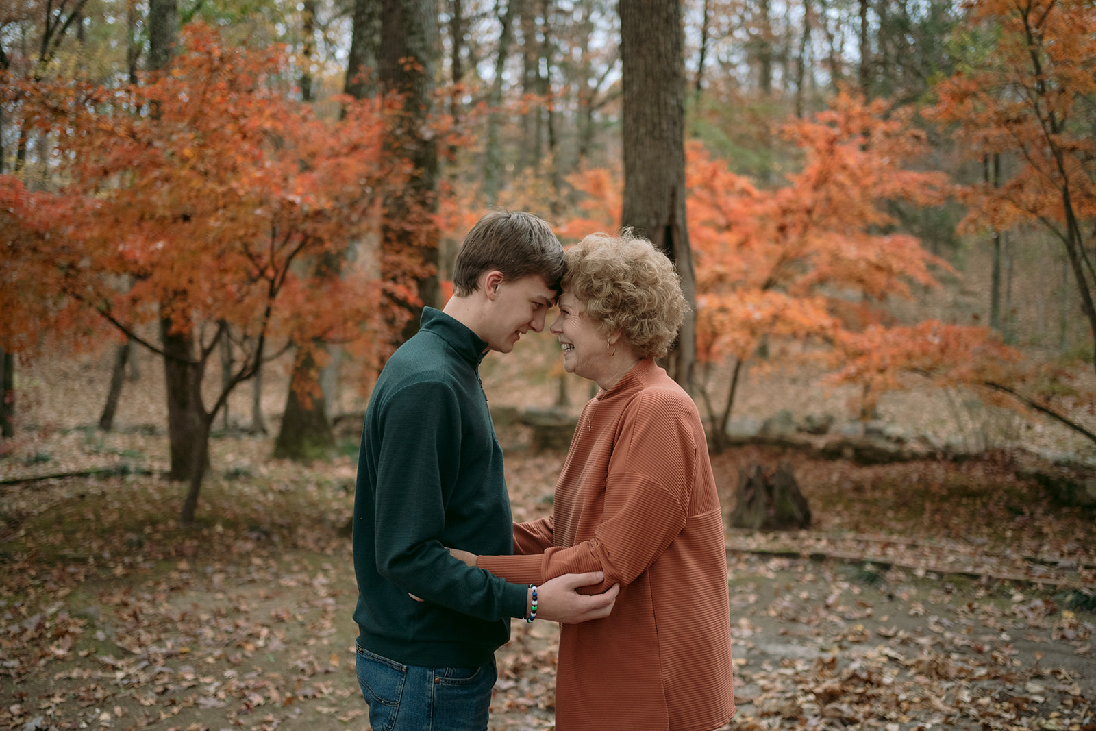 A grandmother and grandson having a sweet moment together hugging before their fall family photo session